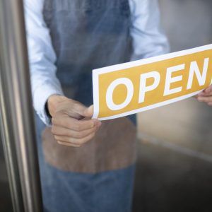 close-up-hands-holding-open-sign